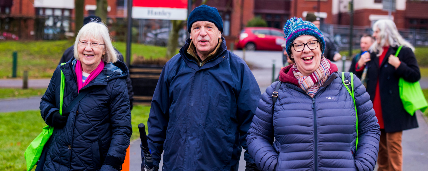 three older people walking and laughing