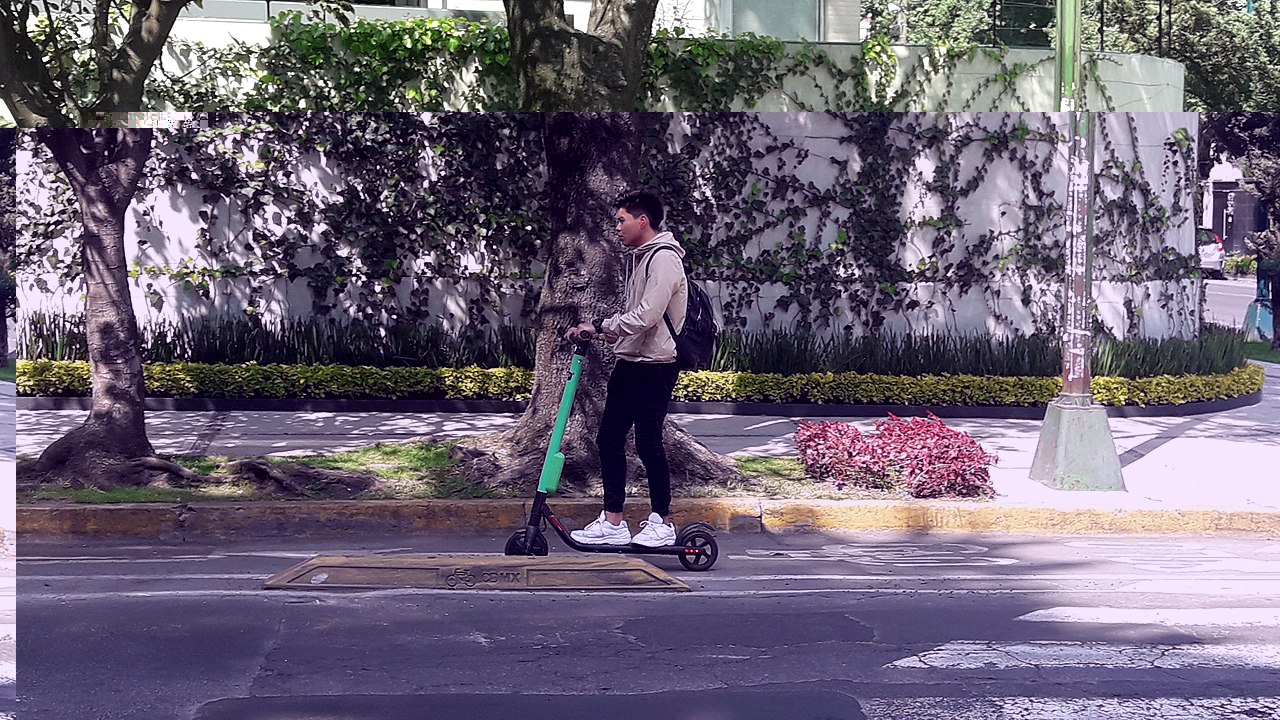 A photo of someone using an e-scooter on the carriageway